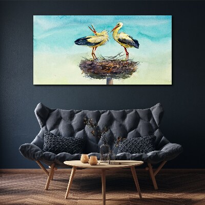 Canvas schilderij Ooievaars op een nest in het blauw