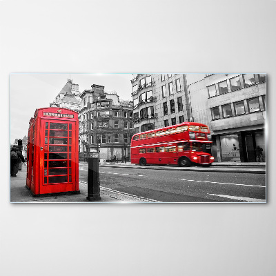 Foto op glas Een rode telefoon in een grijze stad