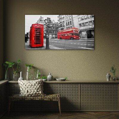 Foto op glas Een rode telefoon in een grijze stad