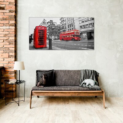 Foto op glas Een rode telefoon in een grijze stad