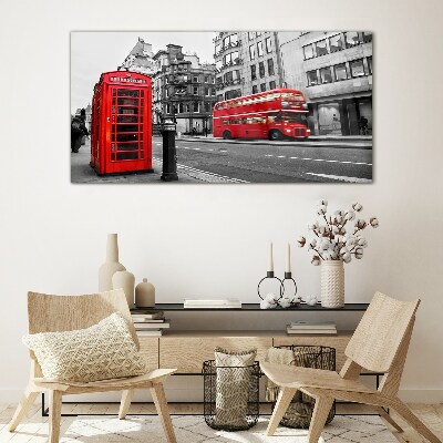 Foto op glas Een rode telefoon in een grijze stad