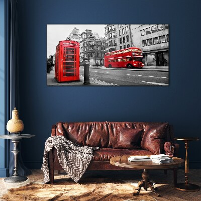 Foto op glas Een rode telefoon in een grijze stad