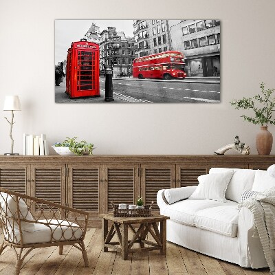 Foto op glas Een rode telefoon in een grijze stad