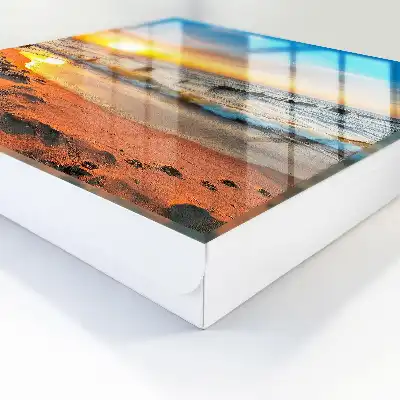 Zonsondergang boven de zee met een strand op de achtergrond