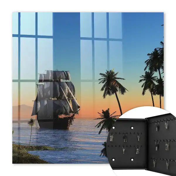 Zeilschip op zee met een palmboom bij zonsondergang