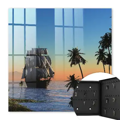 Zeilschip op zee met een palmboom bij zonsondergang