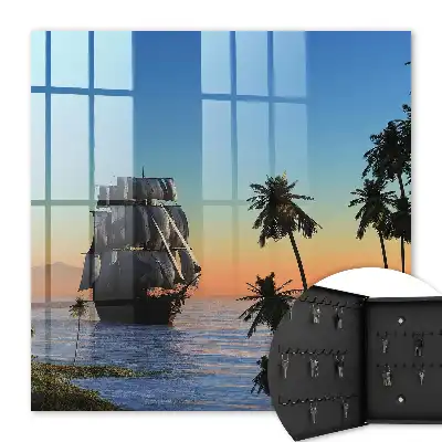 Zeilschip op zee met een palmboom bij zonsondergang