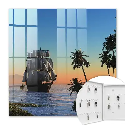 Zeilschip op zee met een palmboom bij zonsondergang