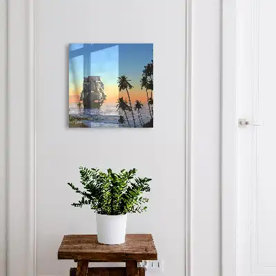 Zeilschip op zee met een palmboom bij zonsondergang