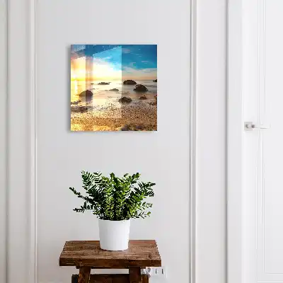 Zonsondergang aan zee met stenen op het strand